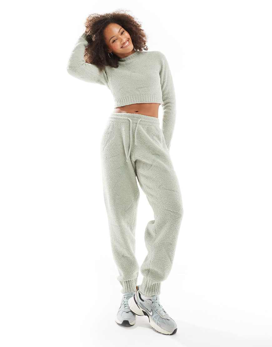 Nike - Phoenix - Bouclé-Jogginghose in Hellgrün mit großflächigem Swoosh-Print und hohem Bund Nike - Phoenix - Bouclé-Jogginghose in Hellgrün mit großflächigem Swoosh-Print und hohem Bund von Nike