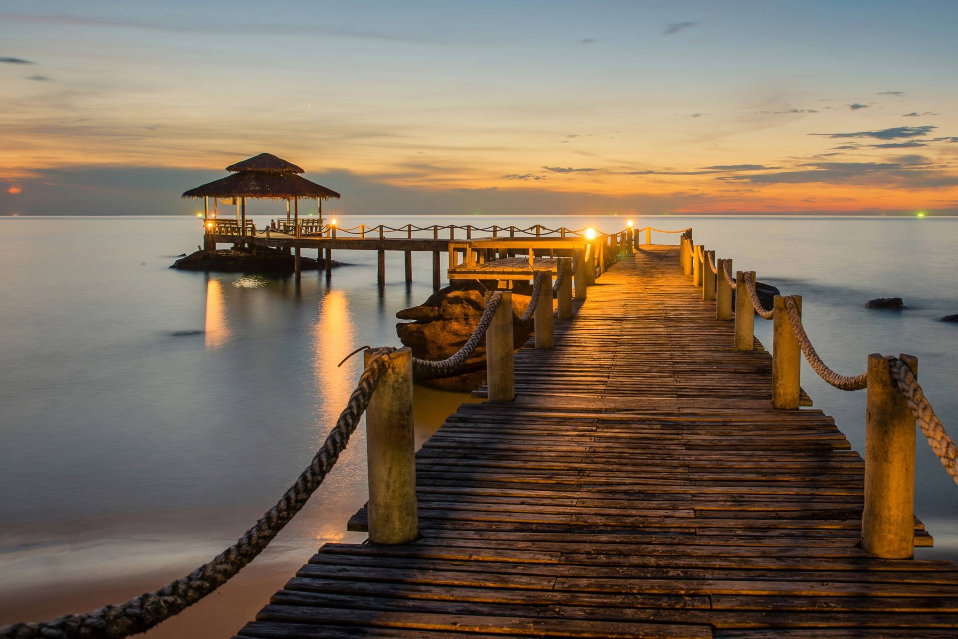 Papermoon Fototapete "Wooded bridge pier between sunset" von Papermoon